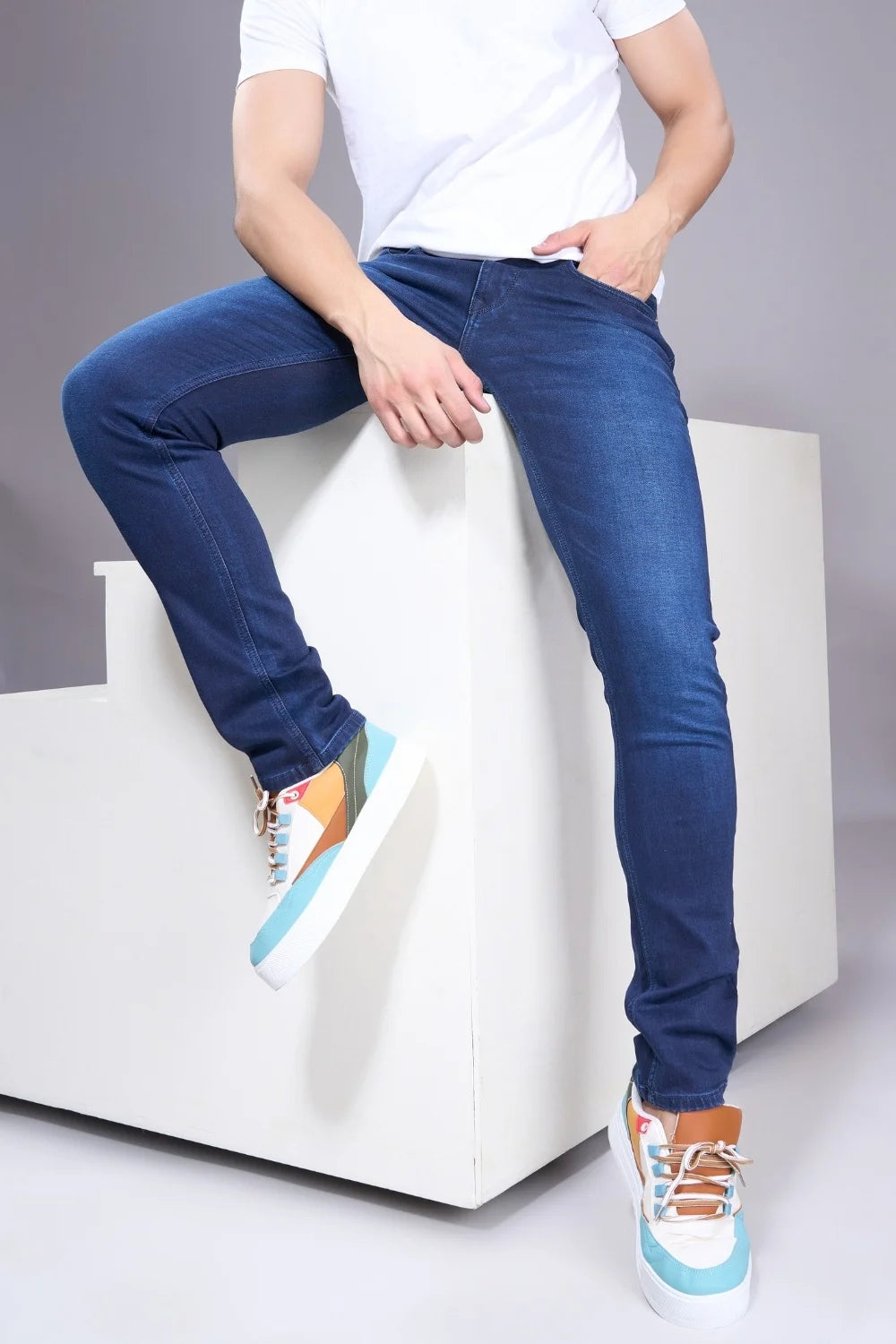 Model styling blue regular fit jeans for men in casual everyday outfit.