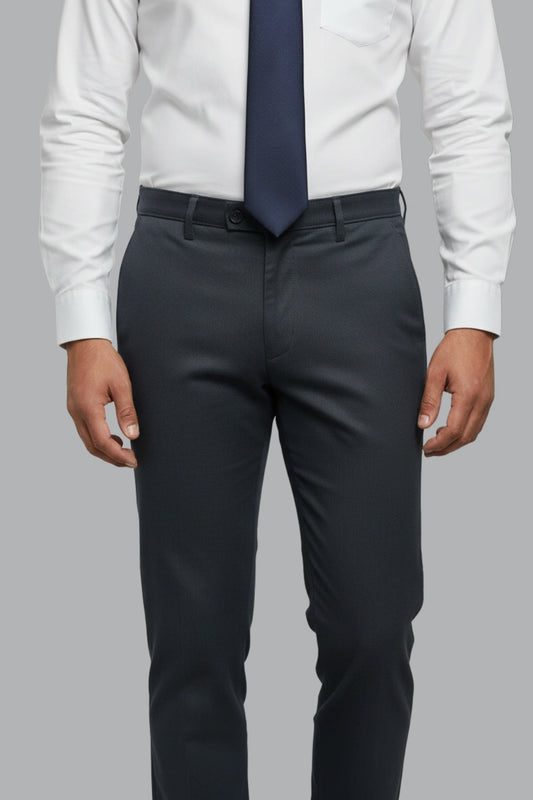 Person wearing a white shirt, navy tie, and blue pants on a gray background
