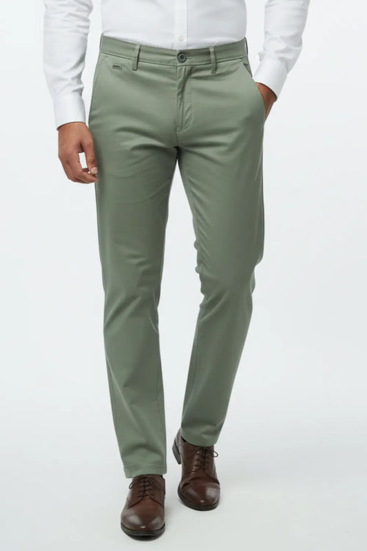 Person wearing olive green cotton pants with a white shirt and brown shoes on a white background
