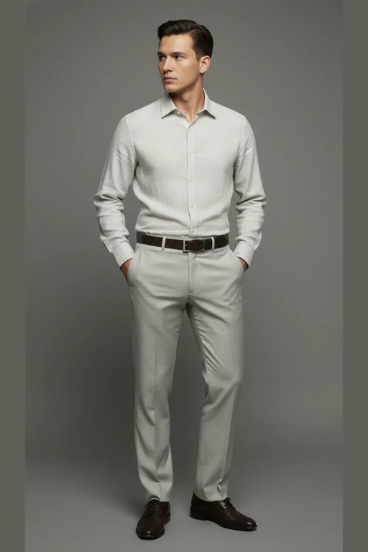 Man wearing a shirt and White pants with a belt, standing against a gray background.