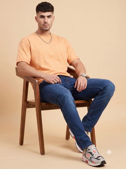 Men's dark indigo slim fit jeans seated view