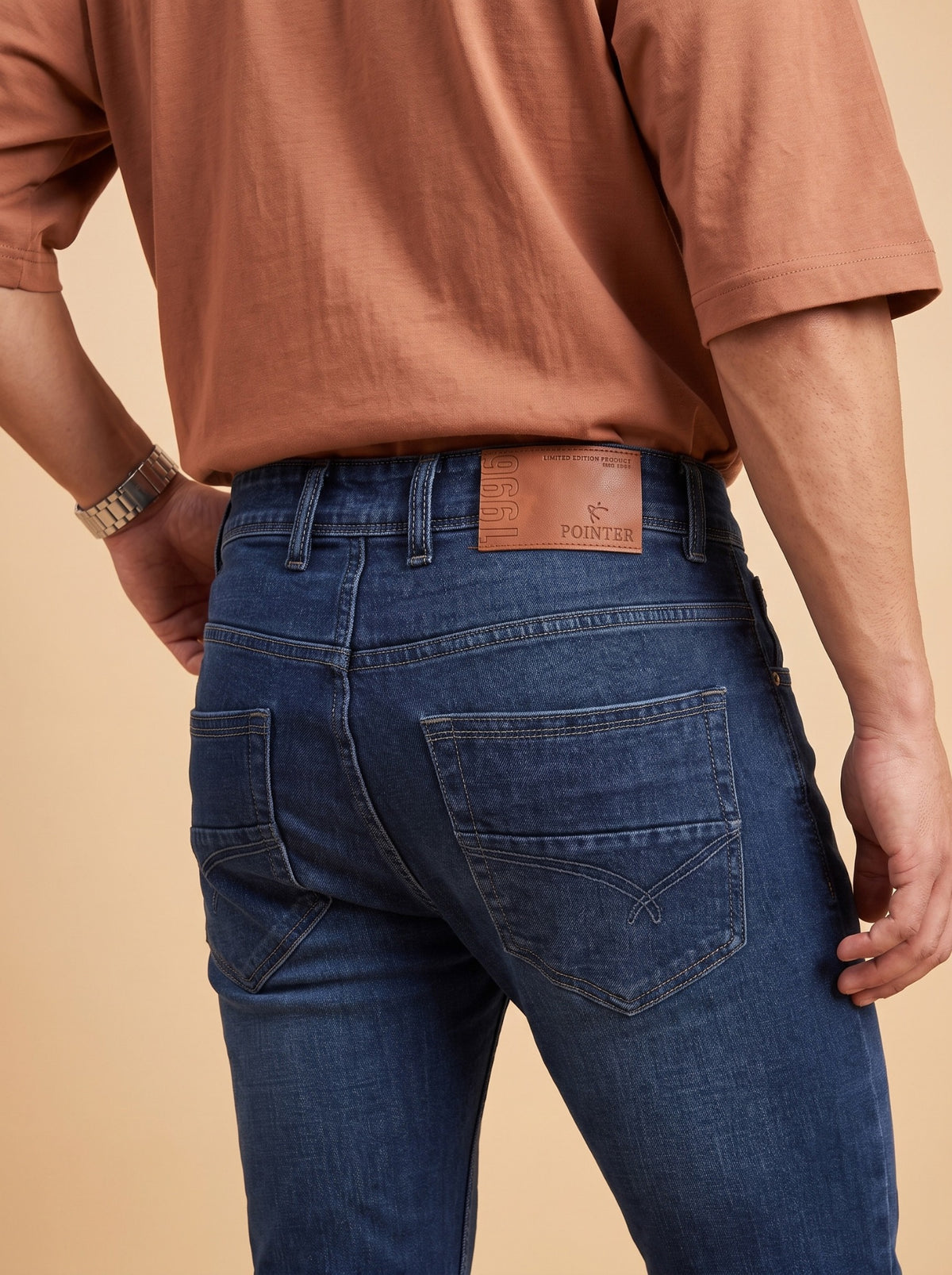 Deep blue jeans rear pocket and branded waistband detail