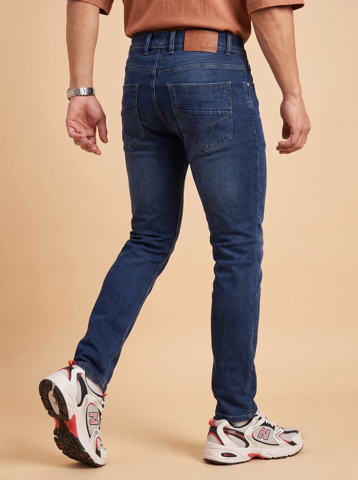 Men's deep blue slim fit jeans rear walking view