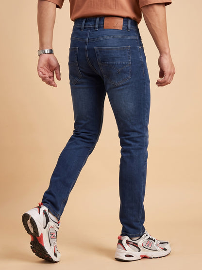 Men's deep blue slim fit jeans rear walking view