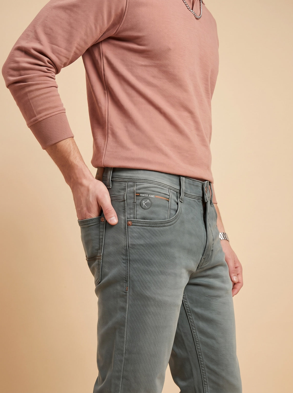Men's sage grey stretch jeans seated cross-leg