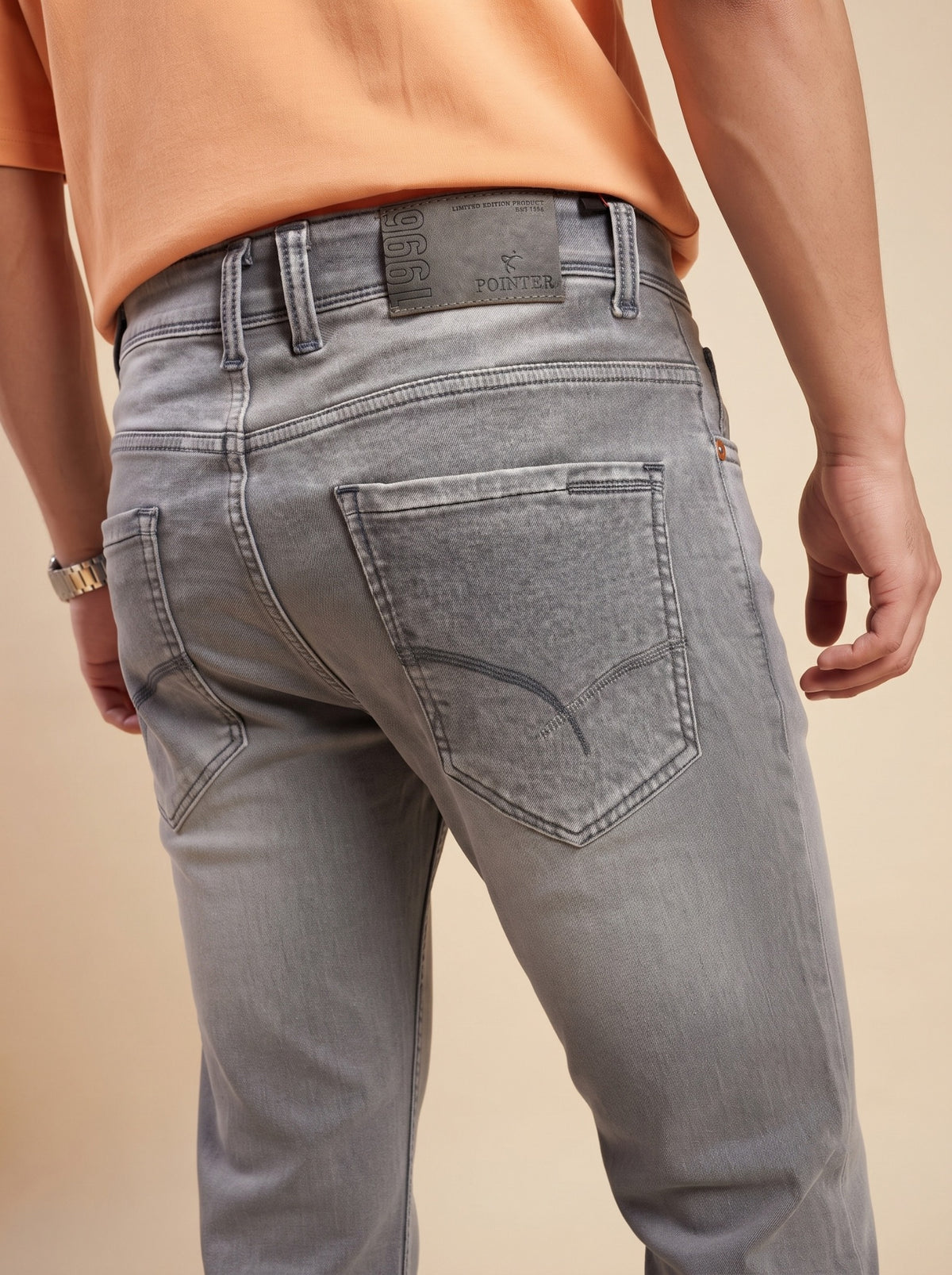 Ash grey denim jeans showing back pocket stitching and waistband detail