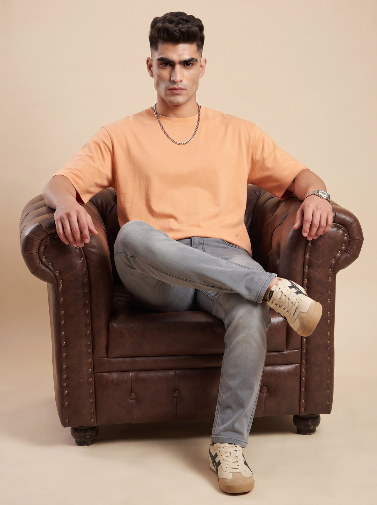 Man wearing ash grey straight fit jeans seated on a sofa