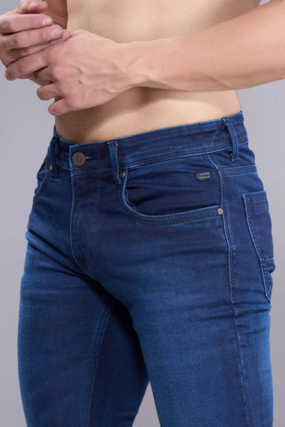 Close-up of blue denim fabric showing texture and stitching of regular fit jeans.
