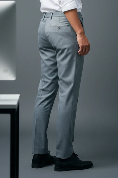 Person wearing light blue dress pants with a white shirt on a gray background