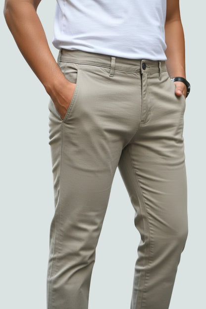 Person wearing brown cotton pants and a white shirt on a light gray background