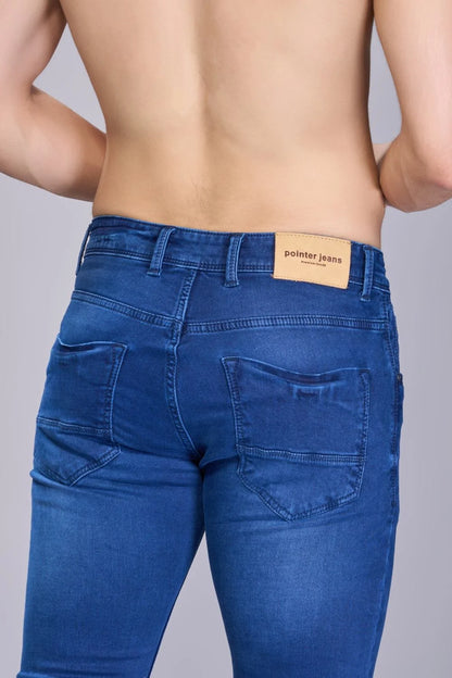 Back view highlighting fit and structure of men’s classic blue denim jeans.
