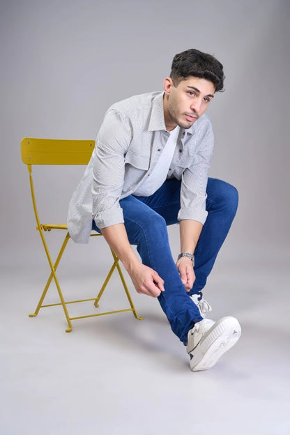 Sitting pose showing men’s classic regular fit denim jeans in blue color.
