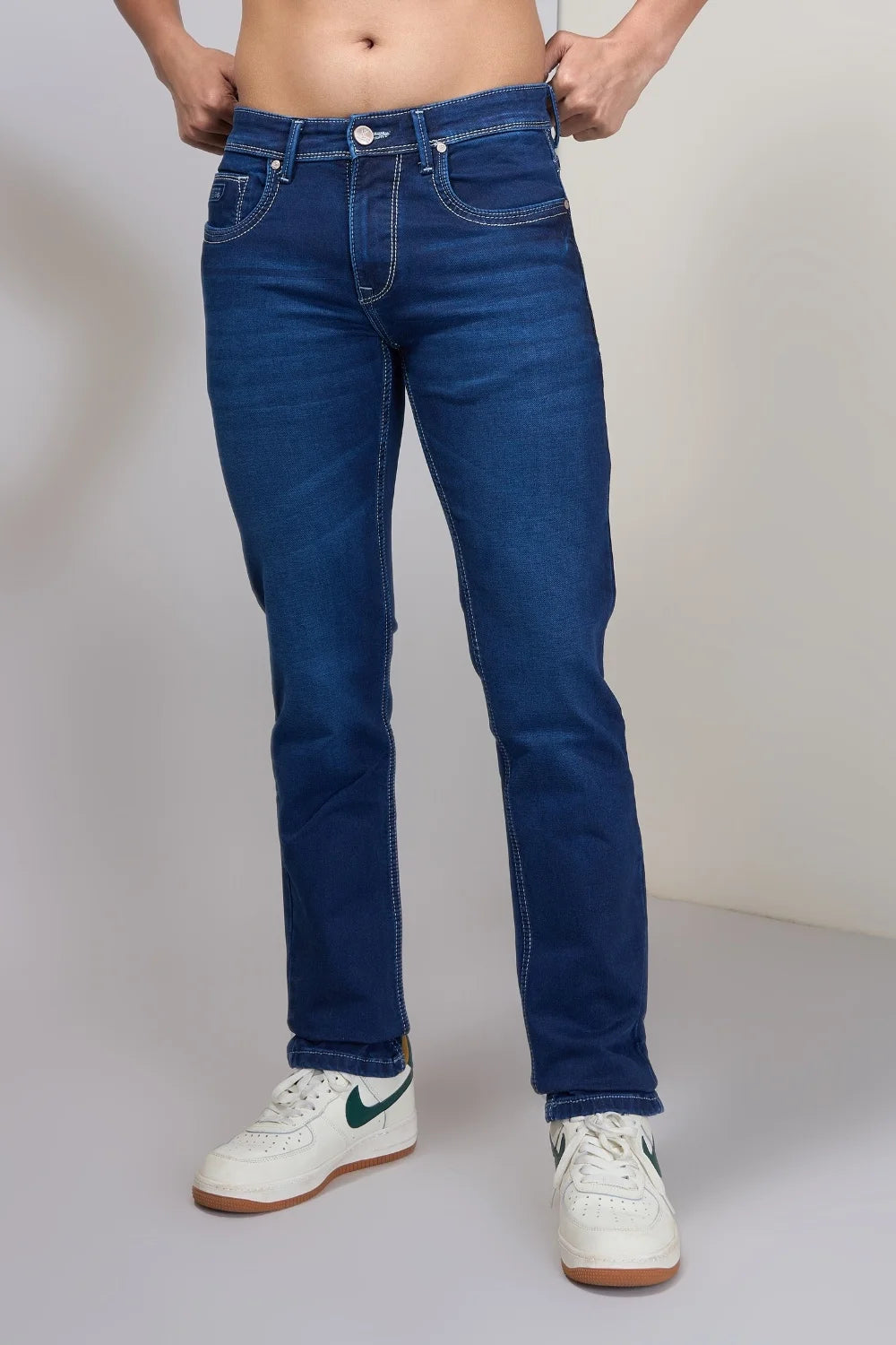 Lifestyle pose highlighting breathable stretch blue jeans for men
