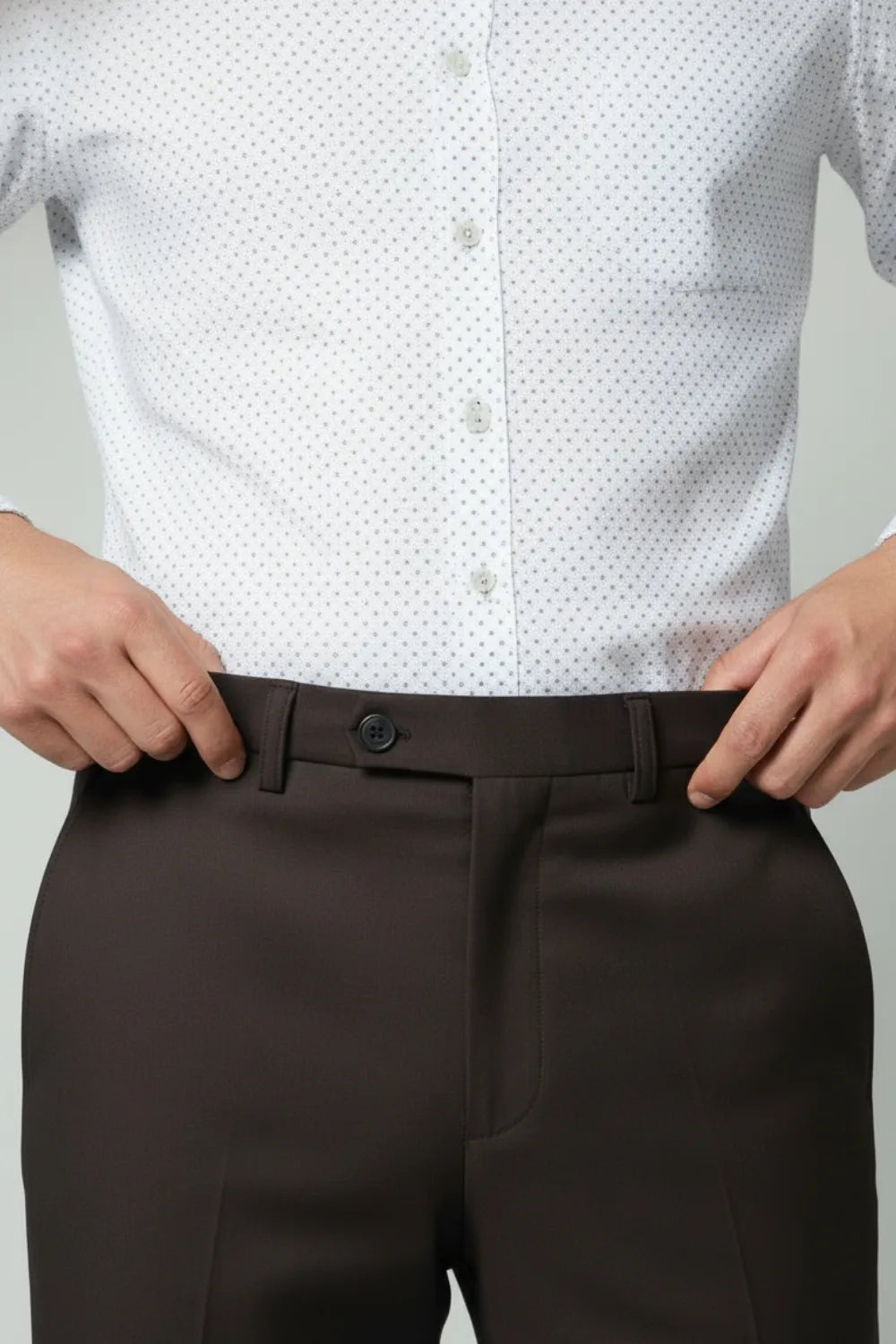 White patterned shirt and brown dark pants closeup view