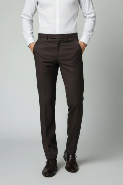 Person wearing a white shirt and dark brown pants on a plain background