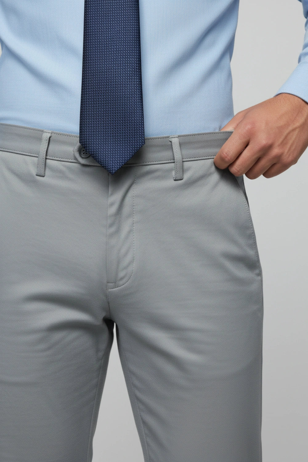 Close-up of the reinforced stitching on the front pocket of grey pants