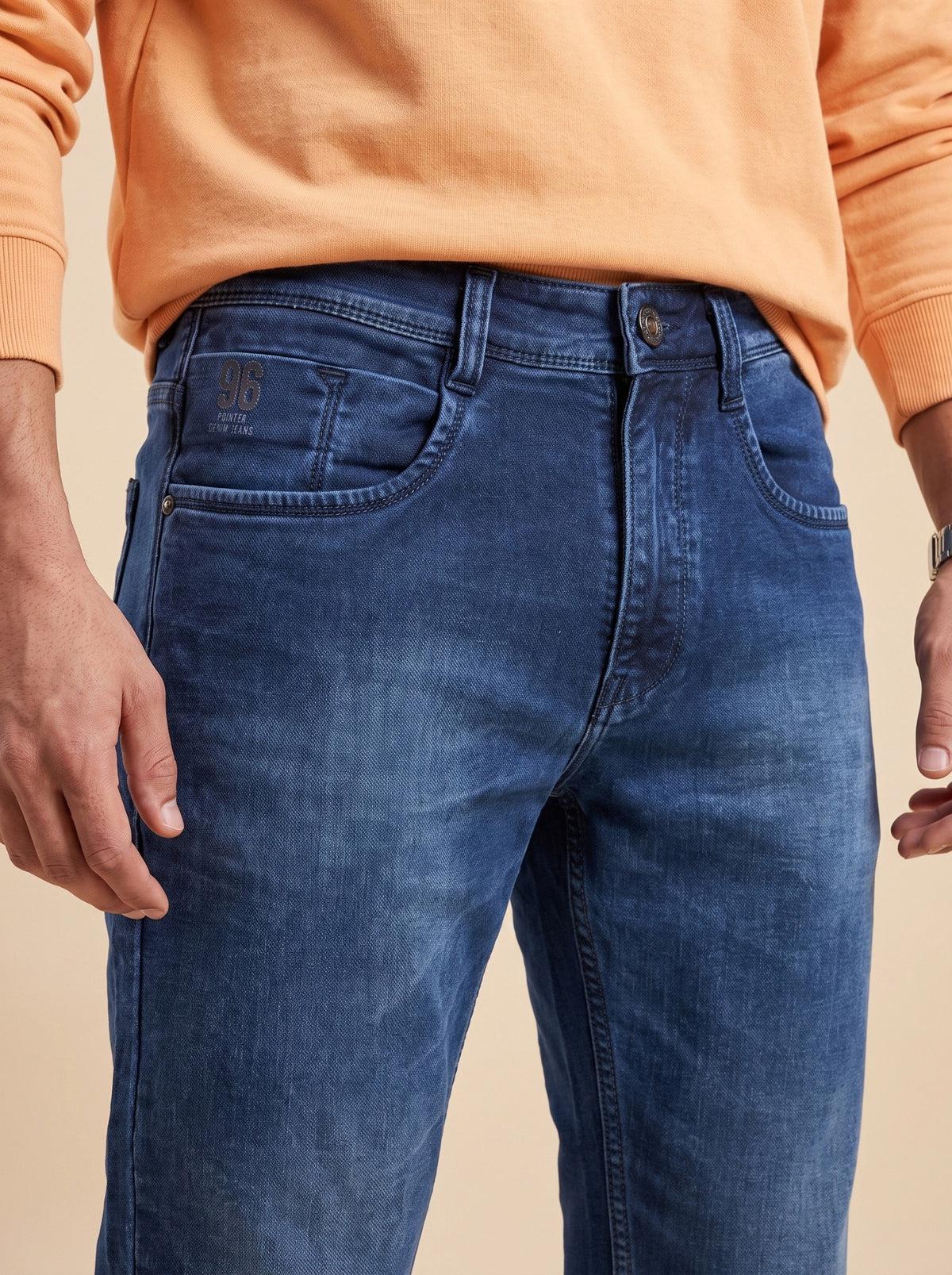 Men's deep indigo jeans showing button closure and washed finish