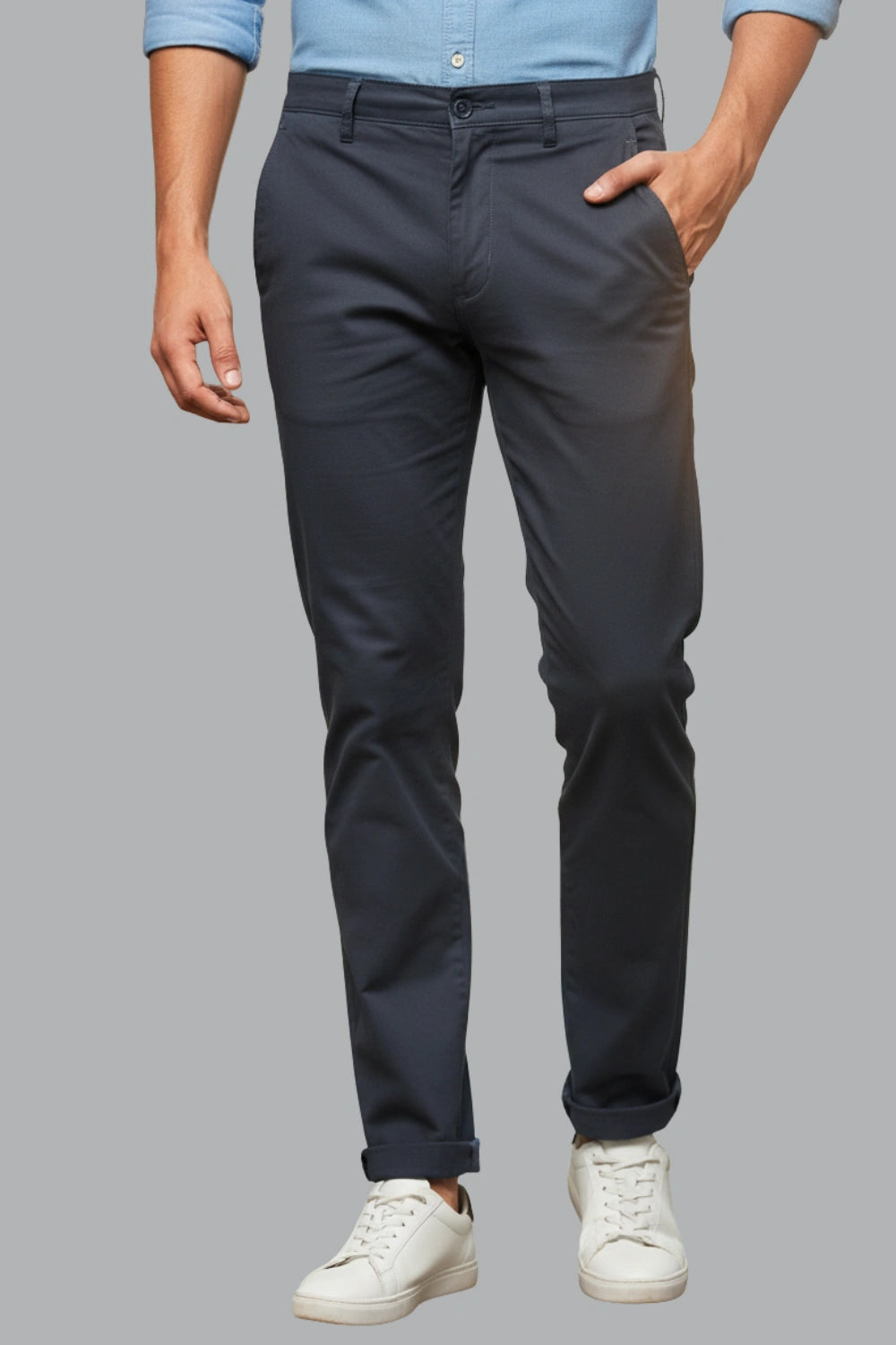 Person wearing a dark pants and a light blue shirt on a gray background