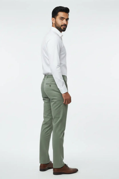 Man wearing a white shirt and green pants on a white background side view