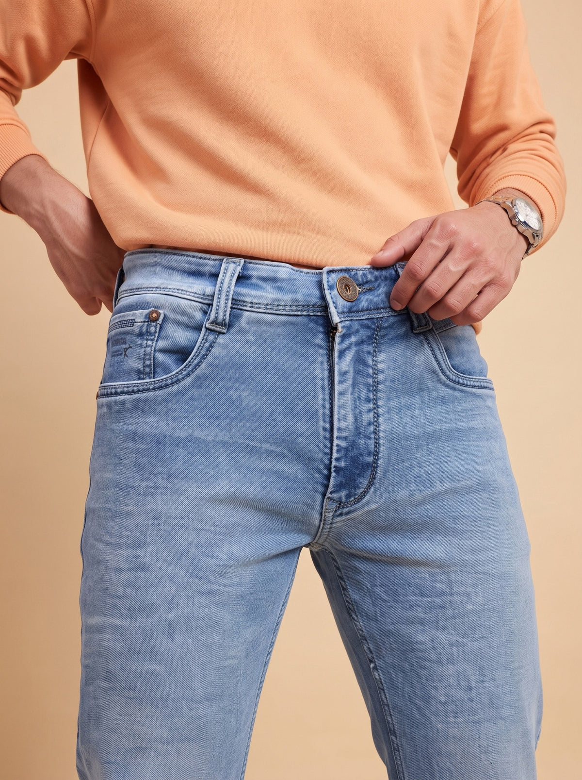 Light blue straight fit jeans showing waistband, button and front pockets