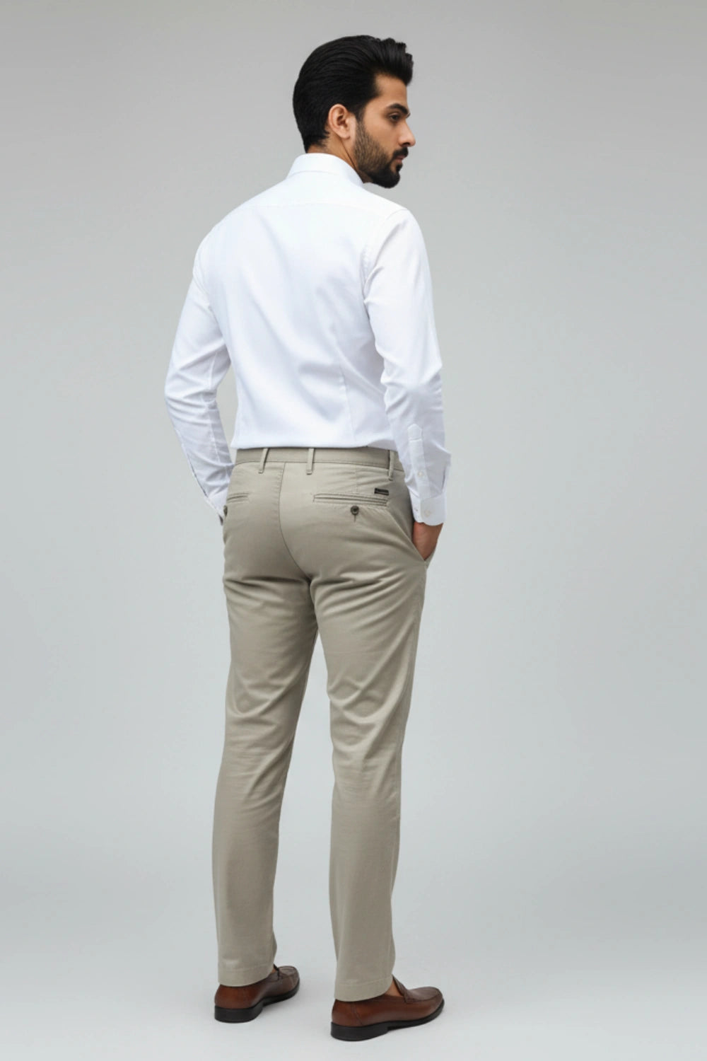 Man wearing a white shirt and beige pants on a gray background