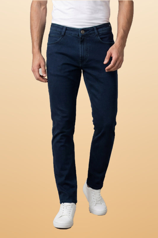 Men's authentic blue slim fit jeans on orange-beige studio background