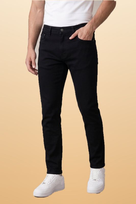 Men's no-fade black slim fit jeans on orange-beige studio background