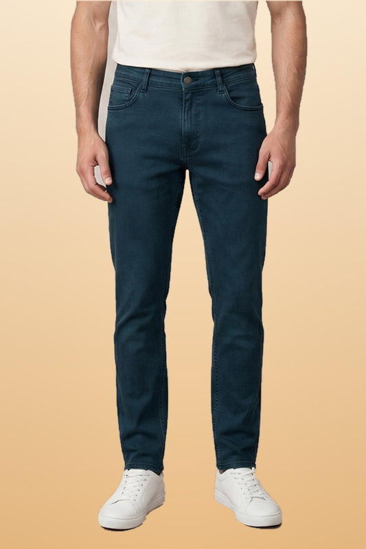 Men's olive green slim fit jeans on orange-beige studio background