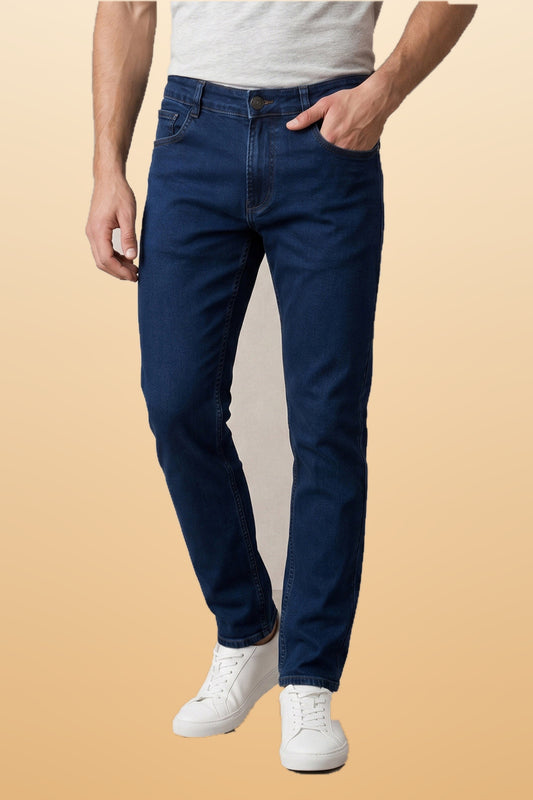 Men's integrity blue slim fit jeans on orange-beige studio background