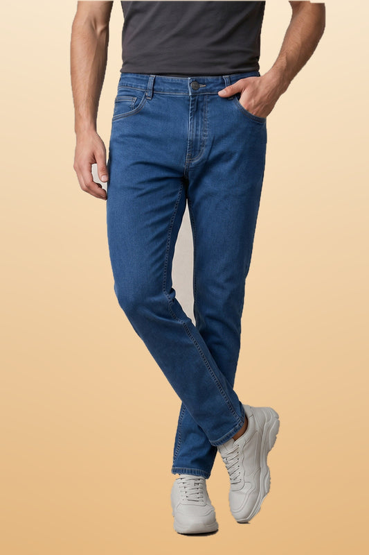 Men's light blue slim fit jeans on orange-beige studio background