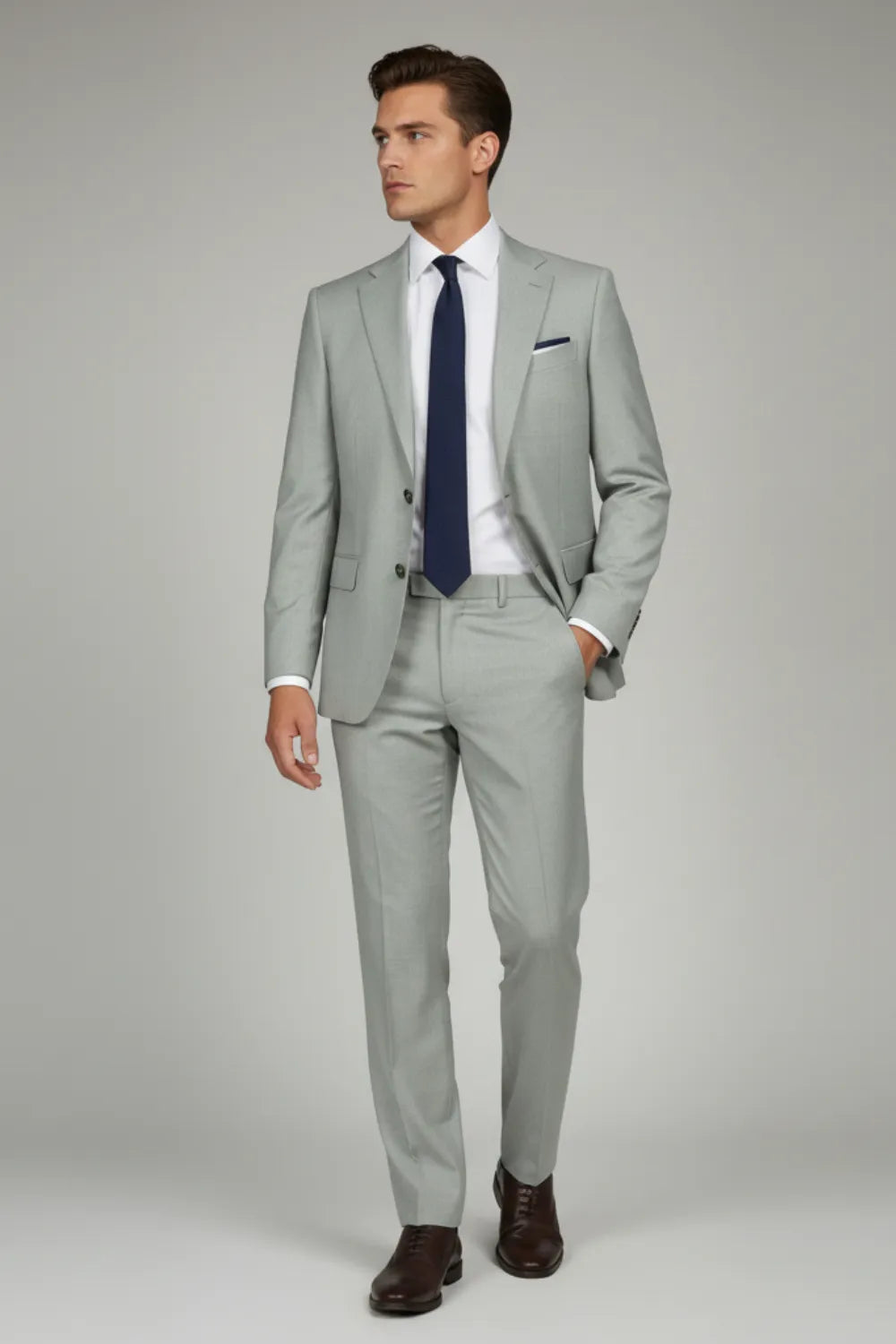 Model wearing white formal pants with grey texture and a white shirt and dark tie on a plain background