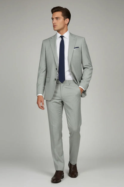 Model wearing white formal pants with grey texture and a white shirt and dark tie on a plain background