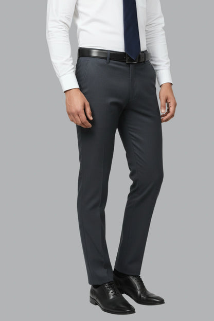 Person wearing a white shirt, dark tie, black belt, and dark blue cotton pants on a gray background