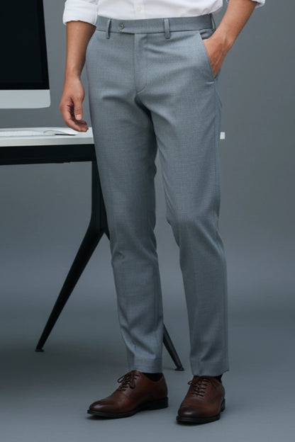 Person wearing sky blue dress pants with a blurred office background