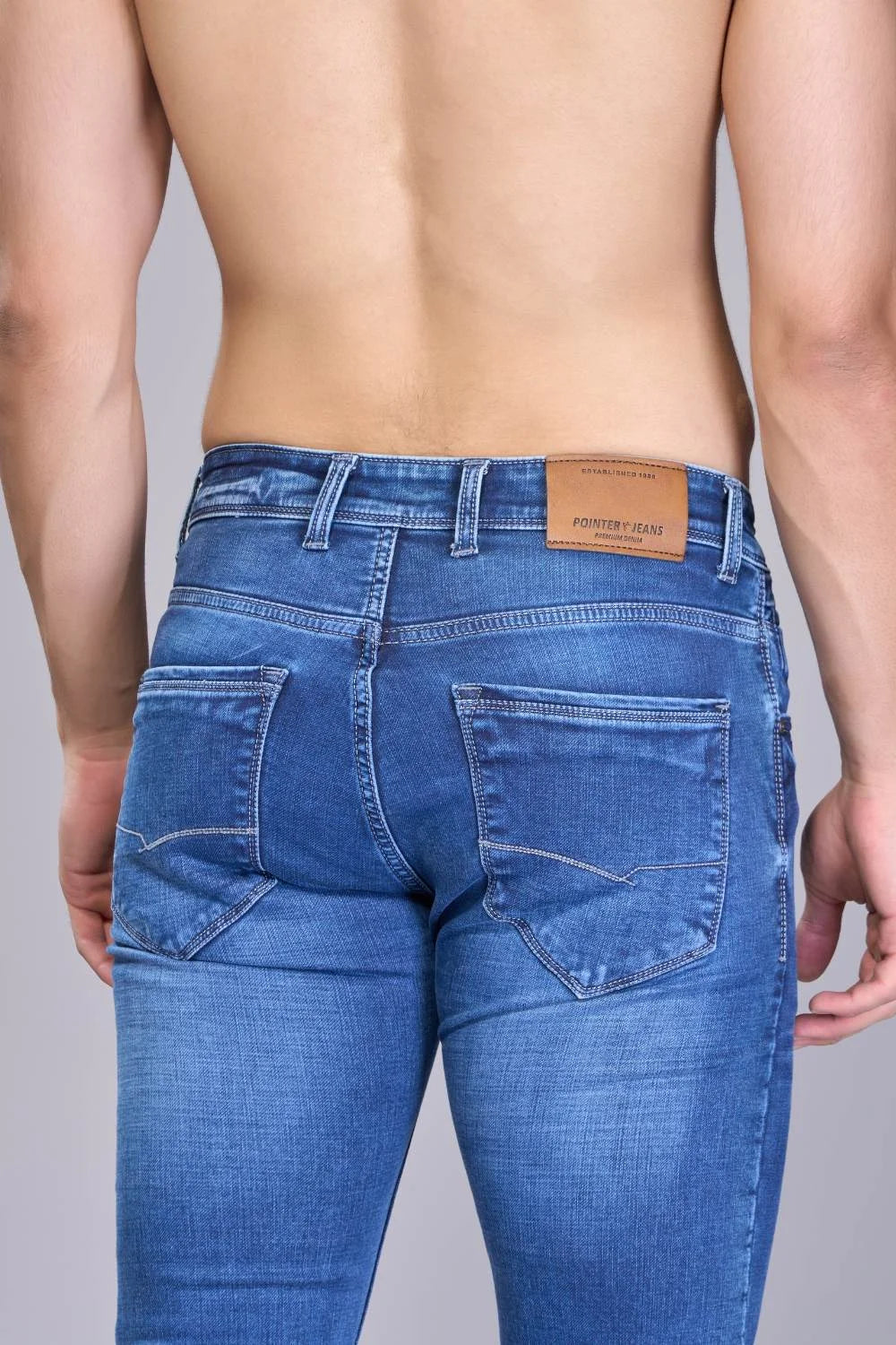 Back fit view of men’s navy blue jeans with straight-cut design
