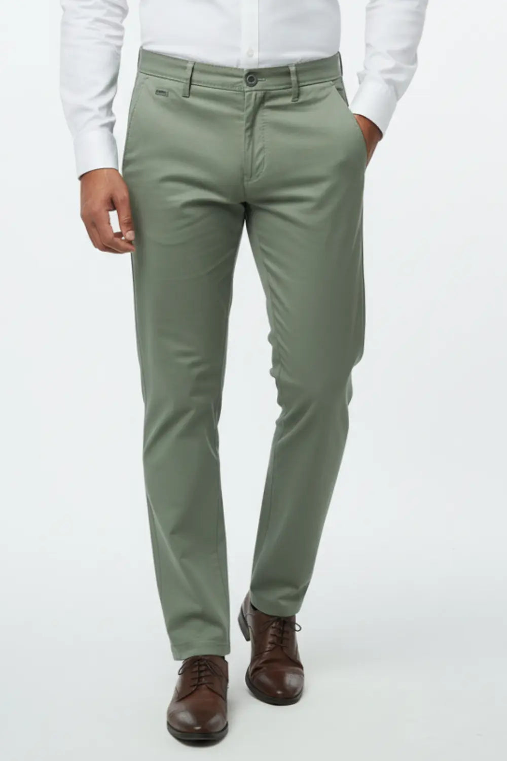 Person wearing olive green cotton pants with a white shirt and brown shoes on a white background