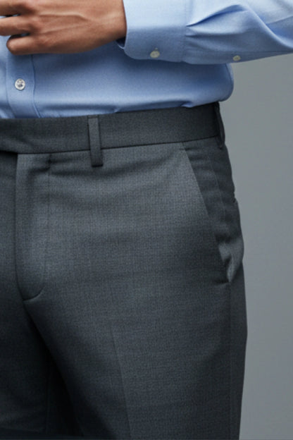 Gray suit pants with a blue dress shirt on a gray background