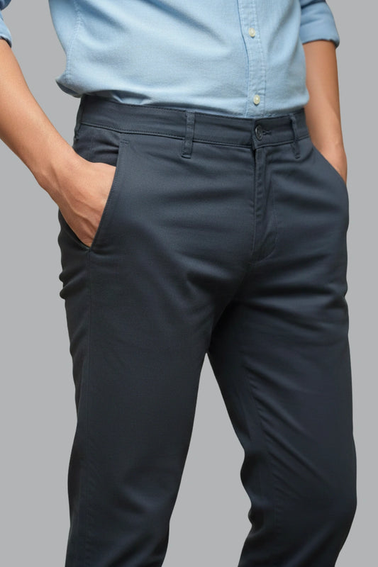 Person wearing dark gray pants and a light blue shirt on a gray background