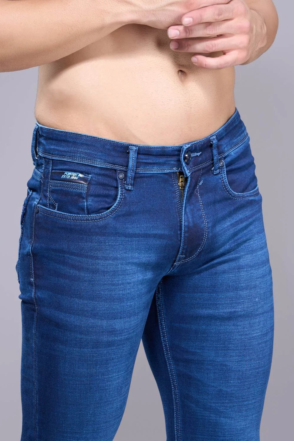 Fabric texture and thigh area close-up of regular fit denim jeans for men
