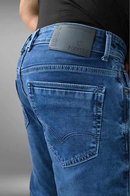 Blue jeans with a brand label on the back pocket against a gray background
