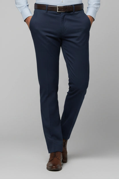 dark blue cotton pants worn with a light blue shirt and brown shoes on a gray background