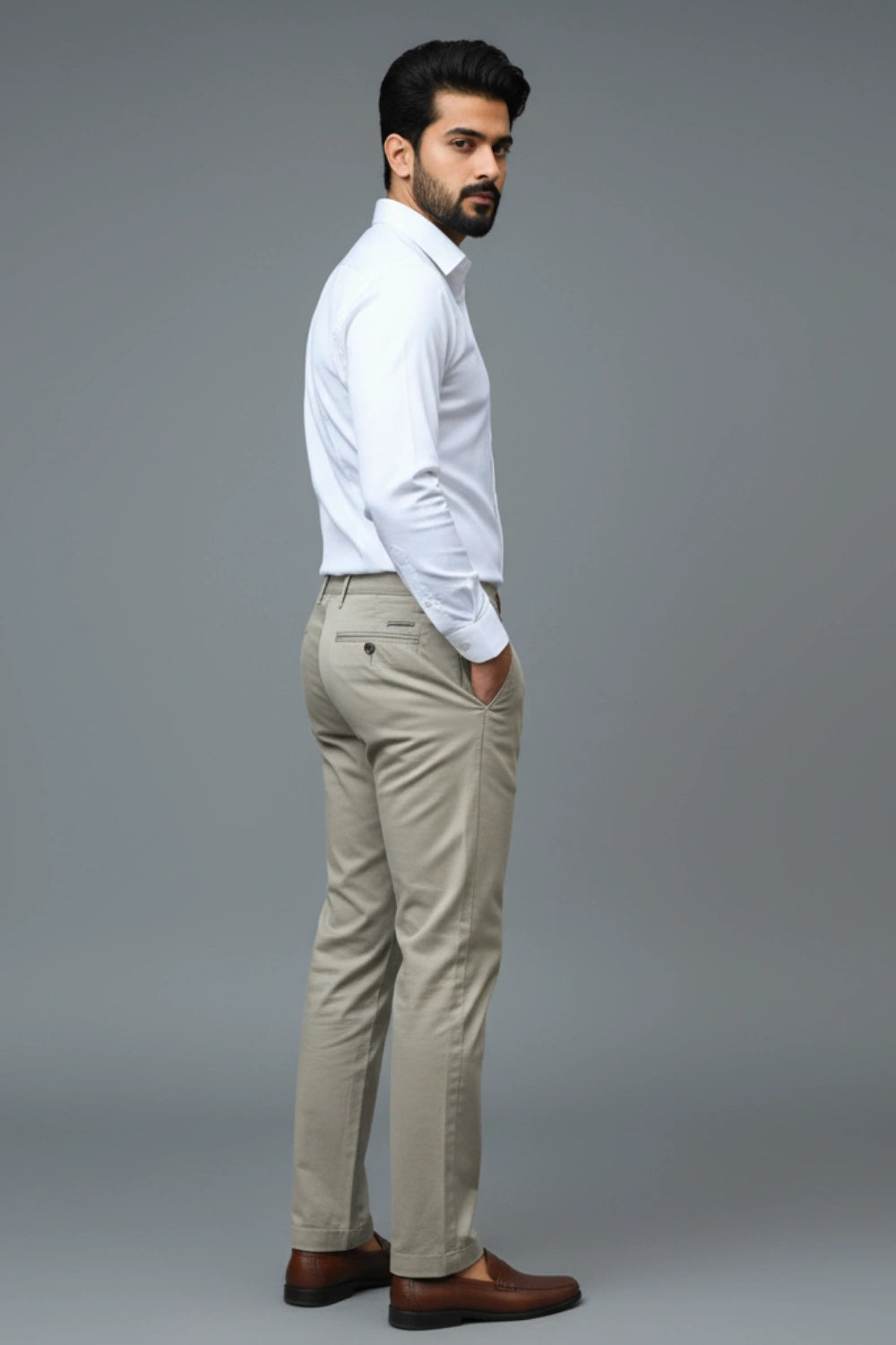 Man wearing a white shirt and Brown pants against a gray background