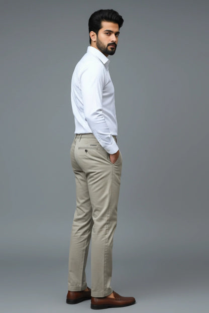 Man wearing a white shirt and Brown pants against a gray background